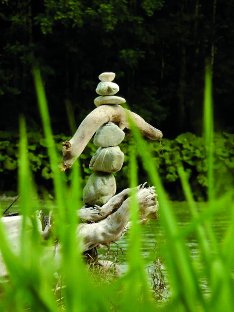 Steinturm aus balancierten Steinen am Wasser